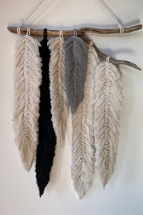 Wall hanging coloured macrame feathers from an organic drift wood