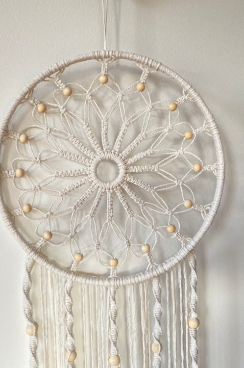 Beautiful off white symetrical dream catcher with golden beads and a long ornate tail