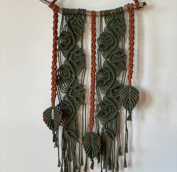 An iIrish macrame wall hanging piece in two colous, hanging from organis drift wood